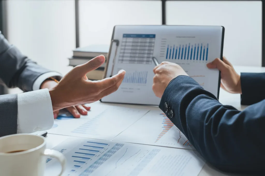 グラフ資料を見ながらデータ分析について打ち合わせをしているビジネスミーティングの様子