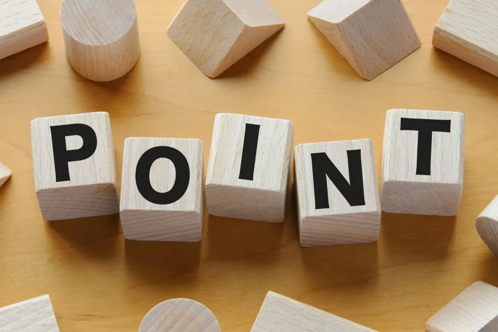 「POINT」の文字が書かれた木製のブロックが並び、周囲にさまざまな形の木製オブジェクトが散らばっている