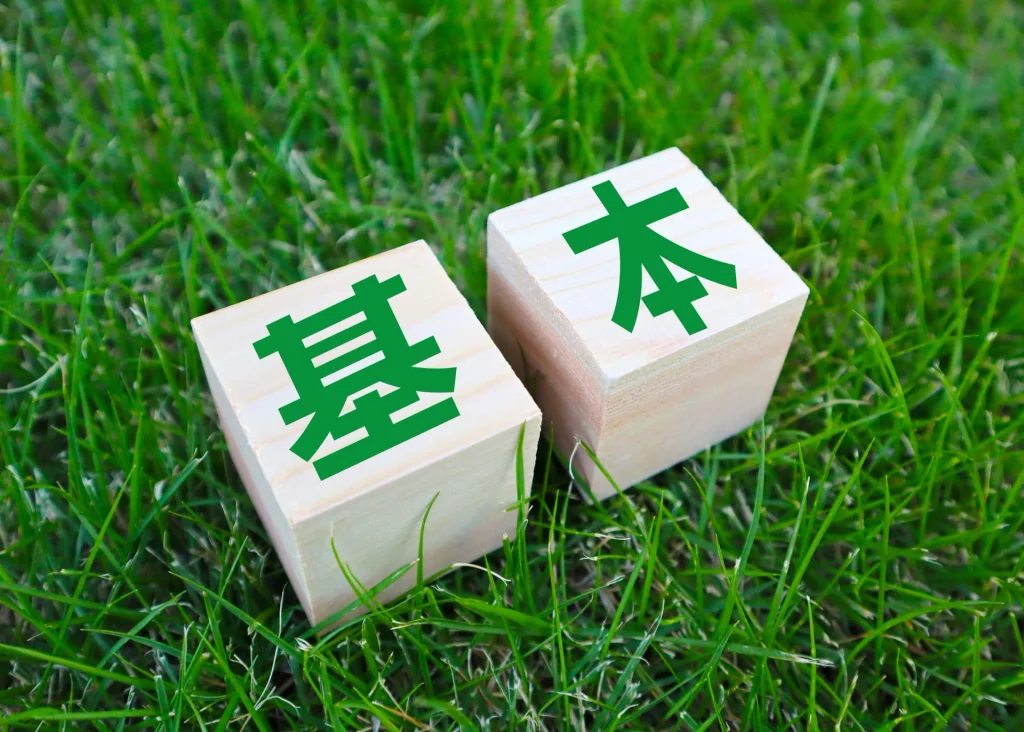 芝生の上に「基本」と書かれた木製ブロック