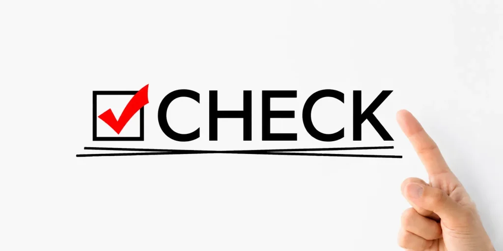赤いチェックマークとCHECKの文字を指差す手