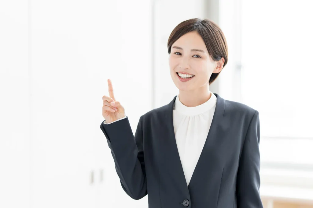 笑顔で人差し指を立ててポイントを示す女性