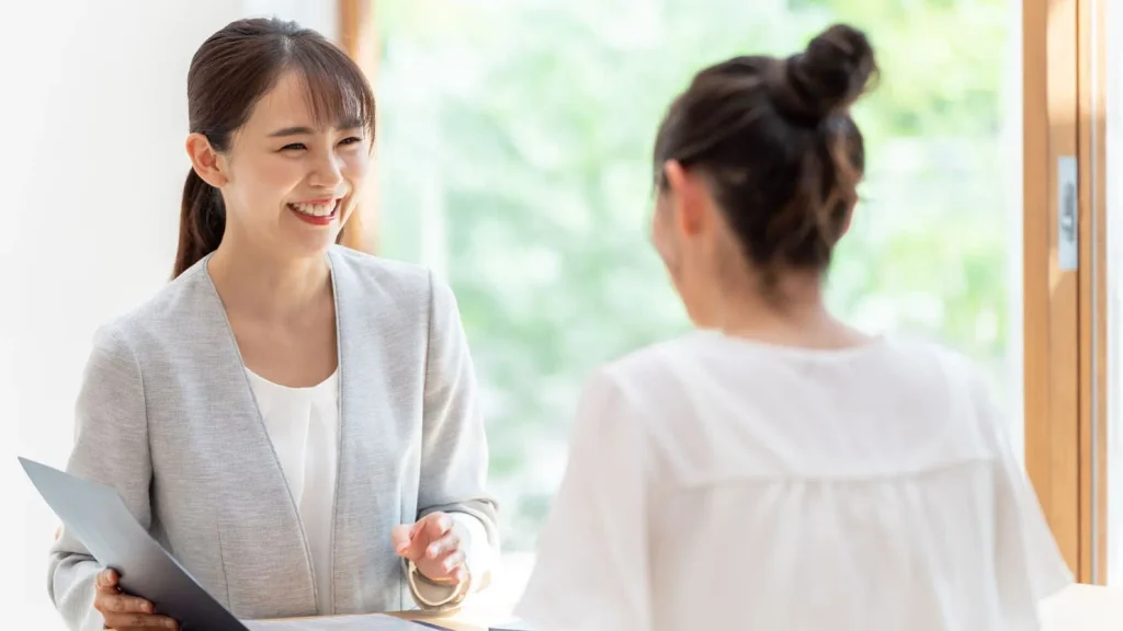 女性スタッフがお客様と笑顔で相談している様子